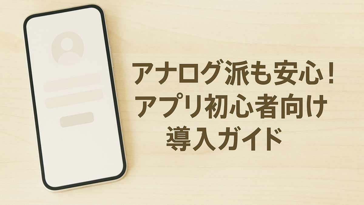 木目の優しいテーブルの上にスマートフォンが置かれ、右側に「アナログ派も安心！アプリ初心者向け導入ガイド」の日本語テキストが中央寄りに配置された画像。ナチュラルな配色でアプリ初心者に寄り添う柔らかい雰囲気が演出されている。
